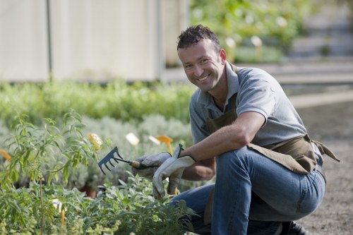 Trainer demonstrating safe equipment operation to gardening staff